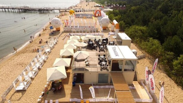 A beachside hotel with outdoor seating, umbrellas, and a view of the sea. - Apartment in Gdynia Near Baltic Beach (Gdańsk)