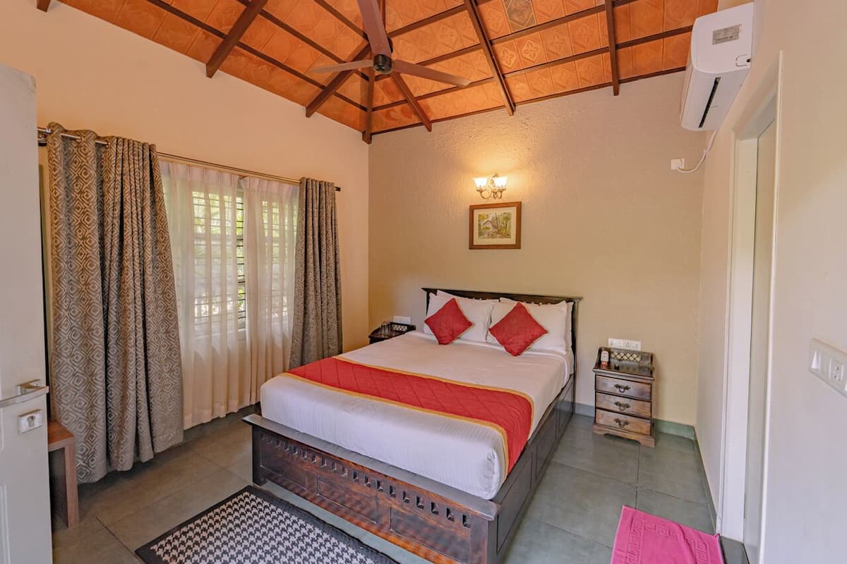 A bedroom with a bed, a nightstand, a dresser, a ceiling fan, and a window with curtains.