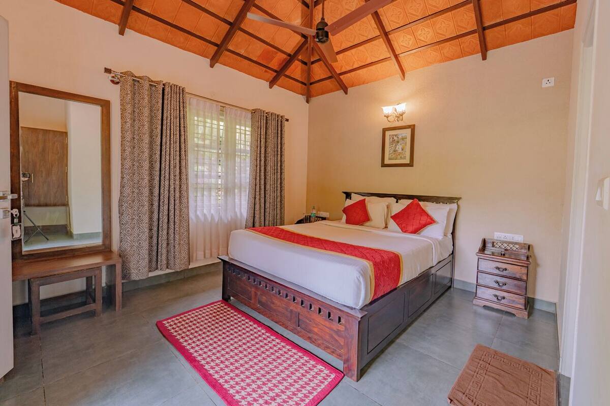 A bedroom with a wooden bed, a nightstand, a mirror, and a ceiling fan.