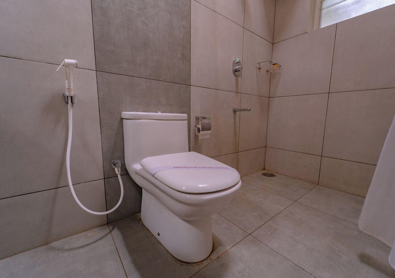 Un baño con inodoro, ducha y secador de manos.