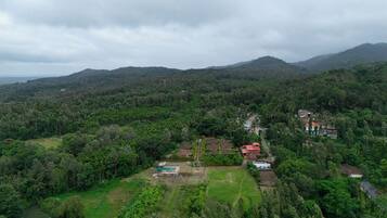 An aerial view of a rural area with scattered houses, a swimming pool, and a river.
