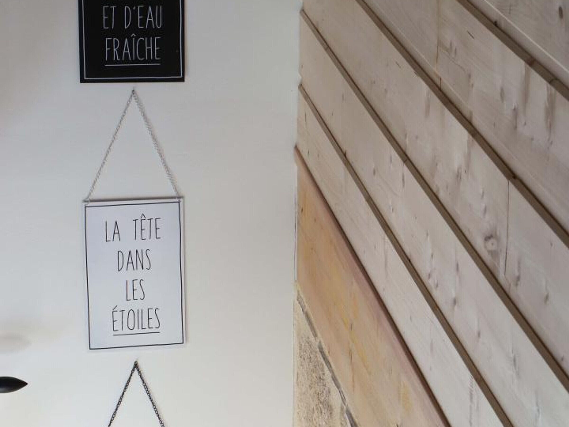 A wall with two signs, one above the other, in a foreign language.