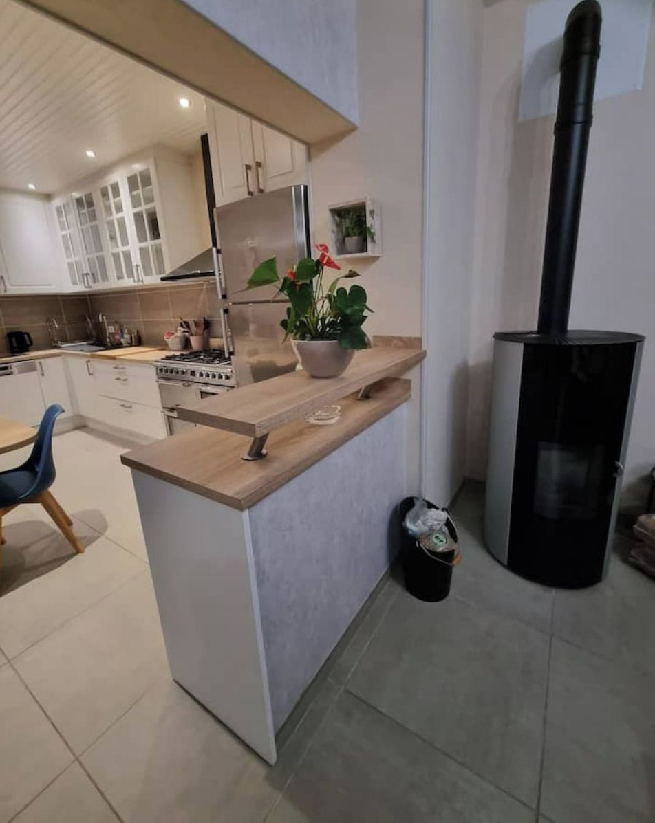 Una cocina moderna con una isla central, una estufa y una campana extractora negra.