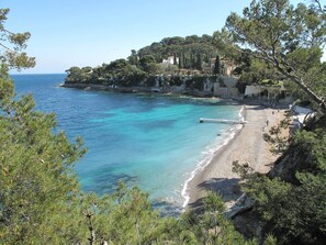 A coastal area with a beach, clear blue waters, and a hillside with buildings. - Charming house in the heart of Cap Ferrat (Saint-Jean-Cap-Ferrat)