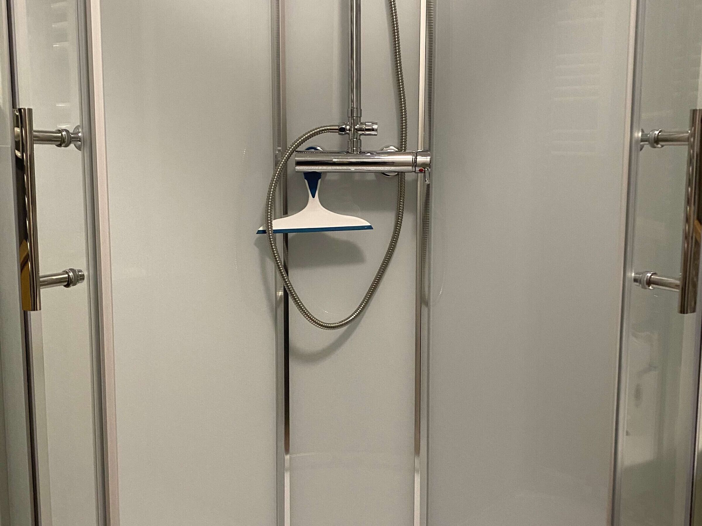 A shower with a handheld showerhead and a handheld hose.