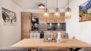 Eine moderne Küche mit Holzausstattung, einem eingebauten Backofen und einem Essbereich mit Holztisch und gepolsterten Stühlen.