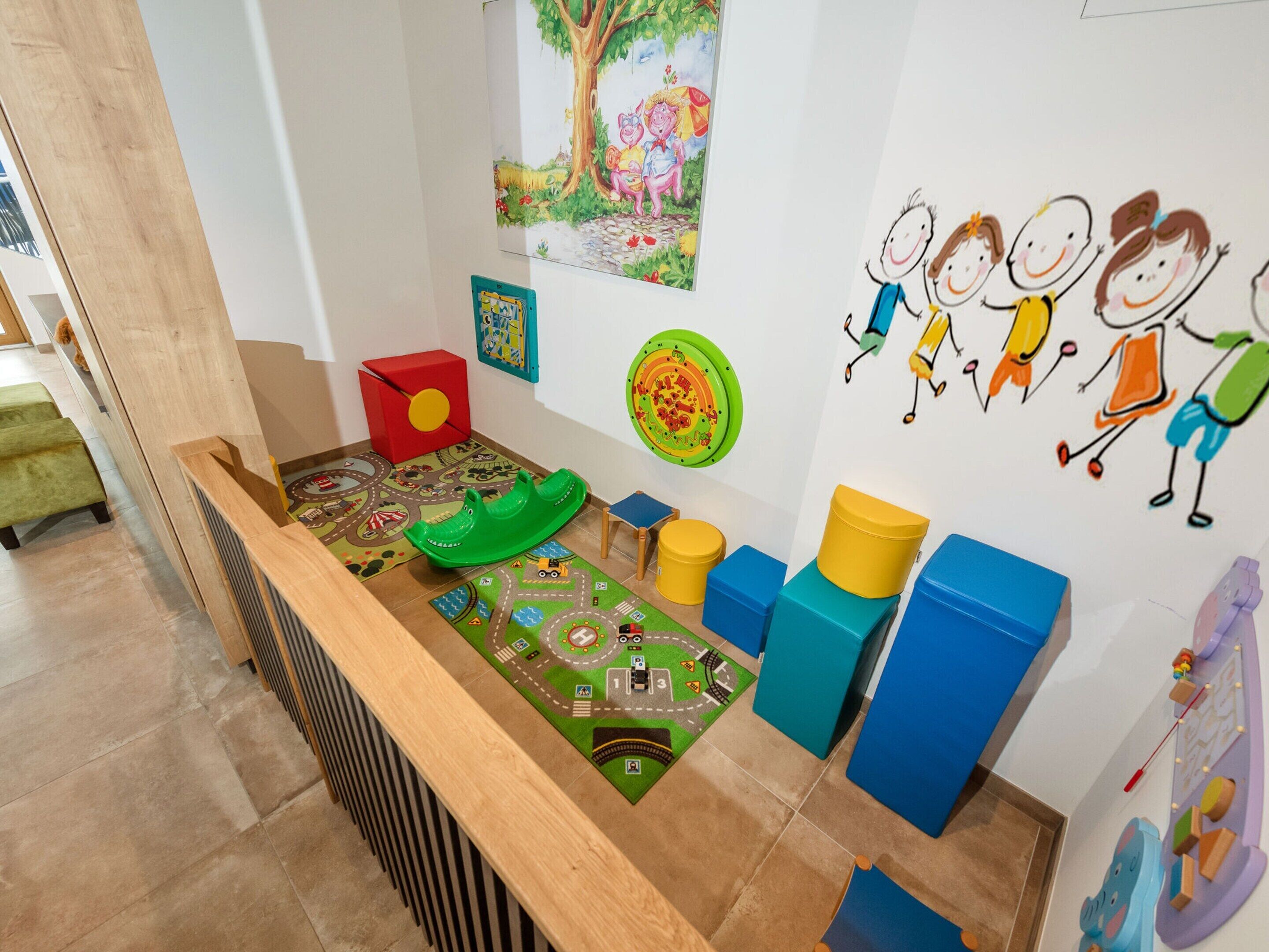 A children's play area with a slide, colorful mats, and educational toys.