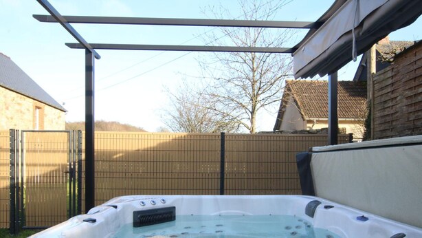 A hot tub in an outdoor setting with a pergola overhead. - Semi-detached house with private spa, pets welcome, near Cotentin (Saussemesnil)