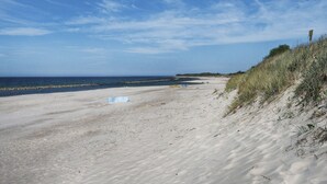 A sandy beach with a clear sky and a rocky shoreline. - Duplex Apartments 300 m From the Sea. Living Room, 2 Bedrooms, own Terrace (Darlowo)