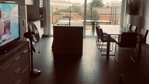 Eine moderne Küche mit Essbereich, großen Fenstern und Blick auf die Nachbarschaft.