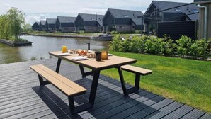 Eine Uferterrasse mit Picknicktisch, Bänken und einem Frühstücksbuffet.
