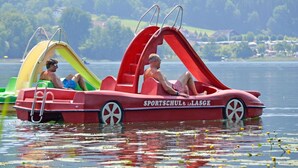 En röd båt med en rutschkana och en person som sitter på den.