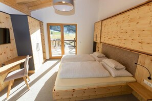 Un dormitorio de madera con cama, escritorio y silla.