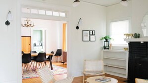 Ein geräumiges Wohnzimmer mit Kamin, einer Essecke und einer Küche im Hintergrund.