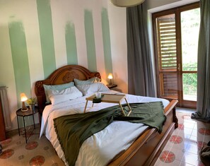 Un lit bien fait, avec des oreillers, une table de chevet avec une lampe et une fenêtre avec des rideaux.