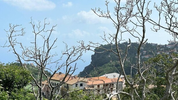 A building with a red roof, surrounded by trees and a cliff in the background. - Wonder House & Panoramic View on the Amalfi Coast (Amalfi)
