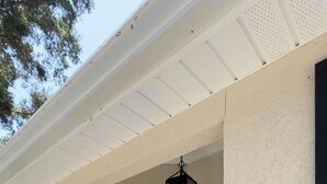 A front entrance with a black door, a black and white striped mat, and a hanging lantern.