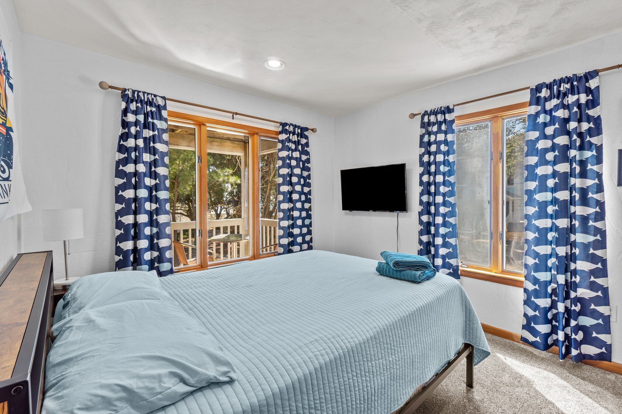 Una camera da letto con un letto, una TV e tende a motivi di pesce.