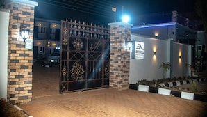 Entrada fechada por portão com uma placa indicando 'EKKULL', possivelmente um hotel ou complexo de apartamentos.