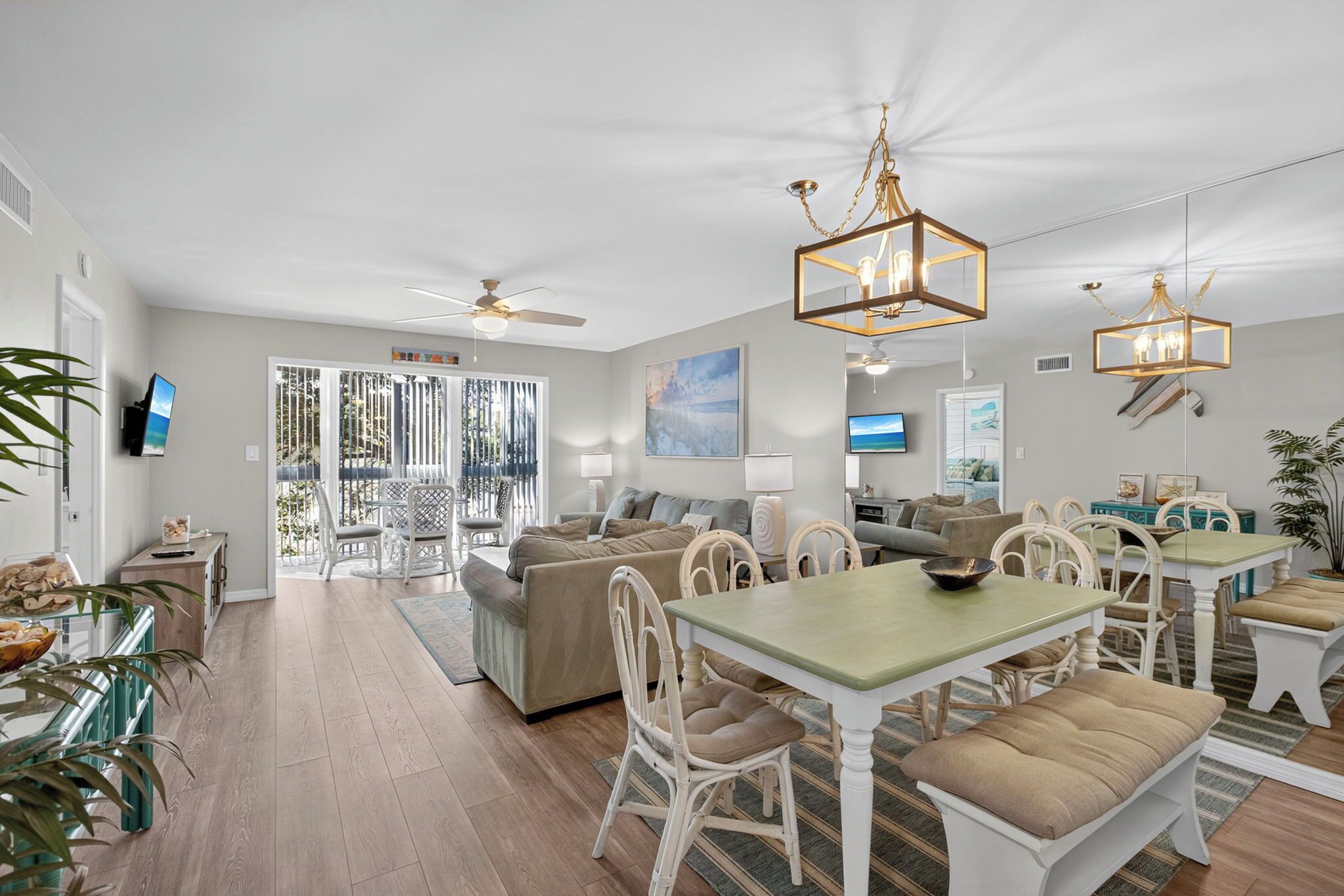 A spacious living area with a dining table, chairs, and a ceiling fan.