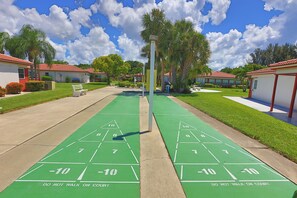Una cancha de shuffleboard con números y una advertencia sobre no caminar sobre ella.