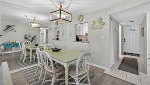 Un espace repas comprenant une table, des chaises et un lustre.