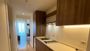 A modern kitchen with wooden cabinets, a stainless steel sink, and a countertop. - Porto Dead Sea  (Sweimeh)