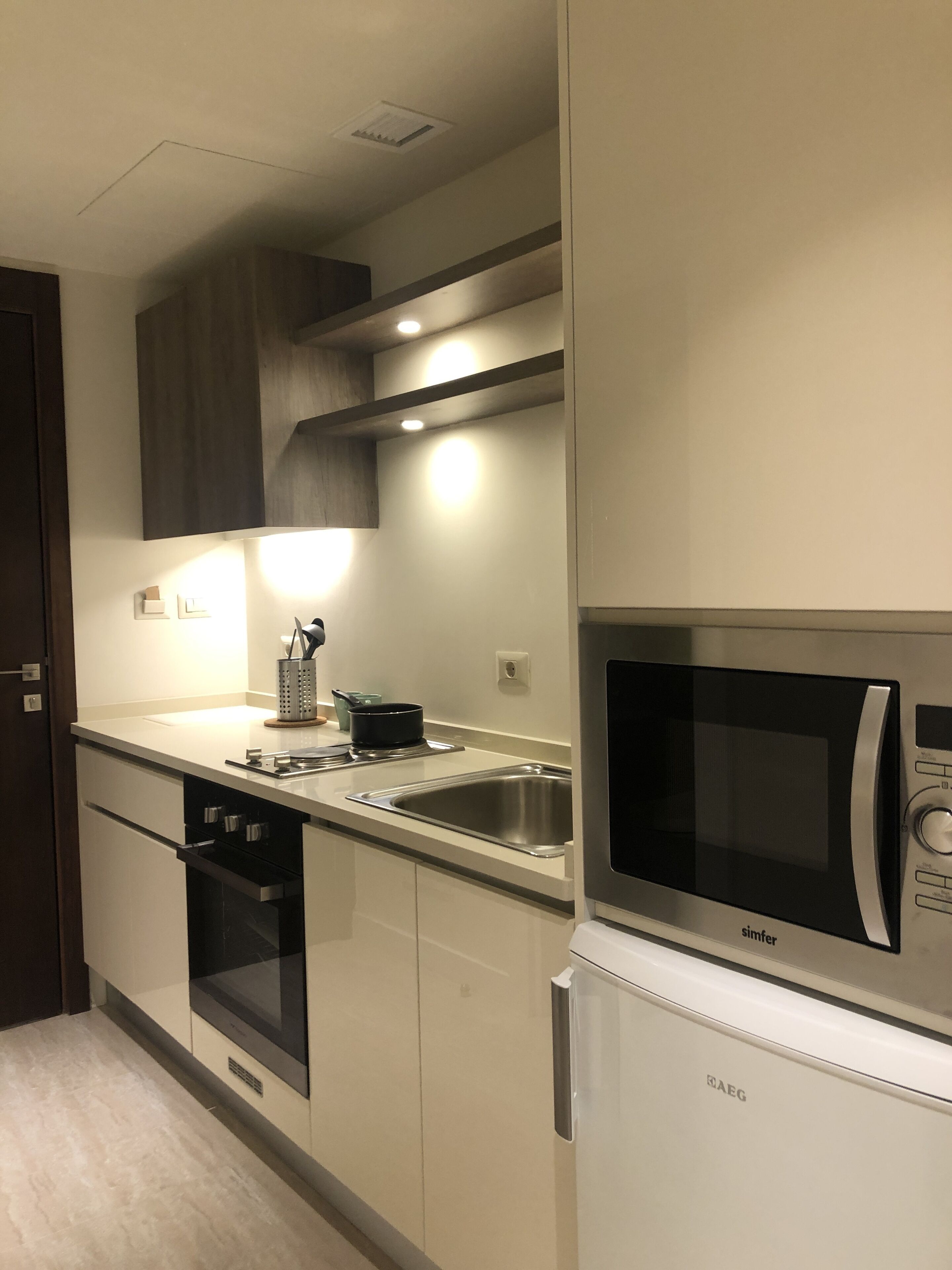 Una cocina moderna con electrodomésticos de acero inoxidable, horno empotrado y microondas.