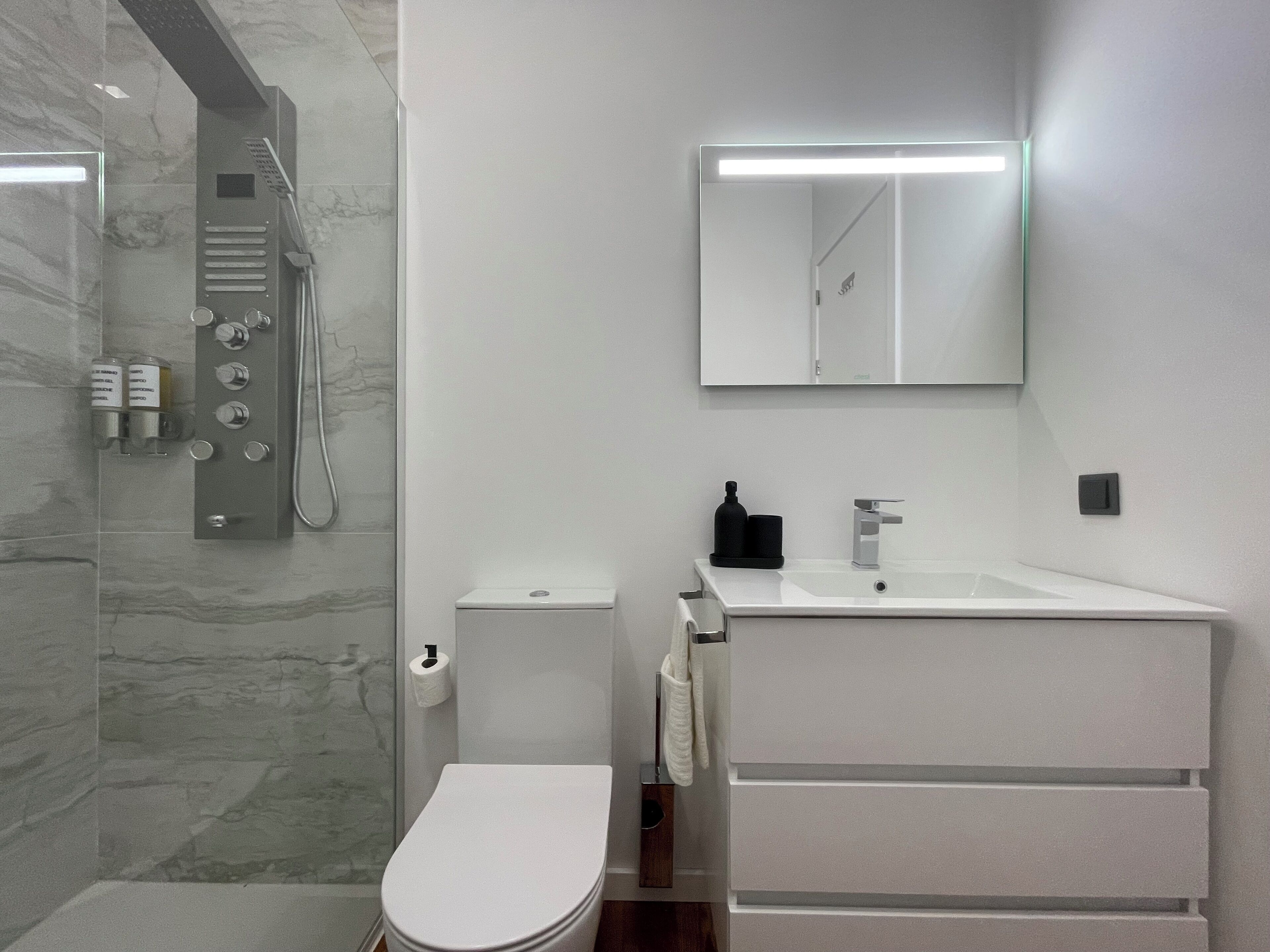 Ein modernes Badezimmer mit Dusche, Toilette und Waschbecken.