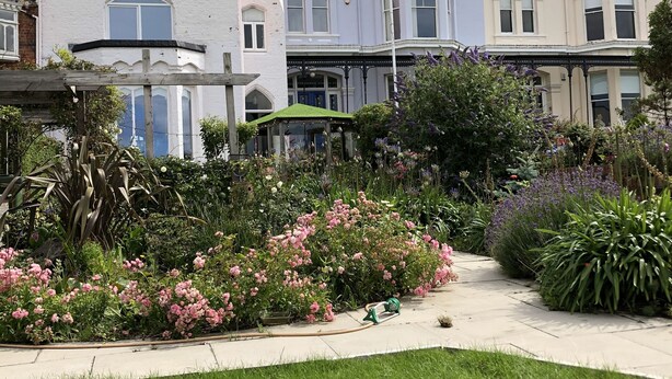 A row of Victorian-style buildings with a well-maintained garden in front. - Charming 2-bed Apartment in Waterloo, Liverpool (Liverpool)