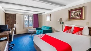 A hotel room with a bed, a desk, a chair, a small table, and a window with curtains. - Hotel Wadsworth OH I-76 (Wadsworth)