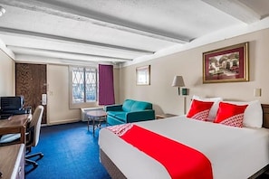 A hotel room with a bed, a desk, a chair, a small table, and a window with curtains. - Hotel Wadsworth OH I-76 (Wadsworth)