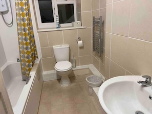 Ein Badezimmer mit Toilette, Badewanne und Waschbecken.