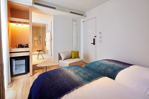 A hotel room with a bed, a small desk, a sofa, a shower area, and a wardrobe. - Tsuki Tokyo (Tokyo)