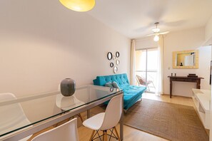 Relax in this stylish room with a glass-top dining table, tufted sofa, and comfortable seating for two.