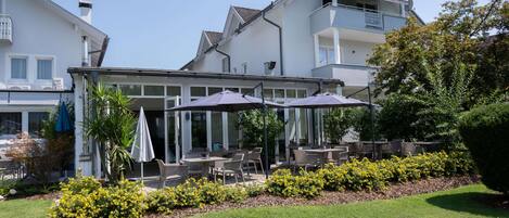 A building with outdoor seating and a garden area.