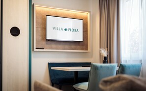 Deluxe Suite | Living area | 82-inch flat-screen TV with satellite channels, TV - Hotel Villa Flora (Velden am Wörther See)