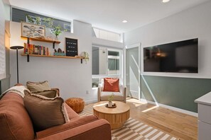 A modern living room with a sofa, coffee table, and bookshelves.