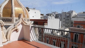 A balcony with ornate white railings and a tiled floor, overlooking a cityscape with various buildings. - Hotel Executive Business (Bari)