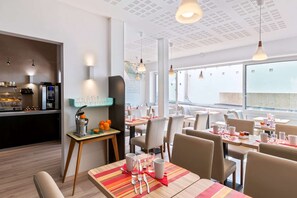 Un restaurant moderne doté d’un bar, de tables et de chaises.