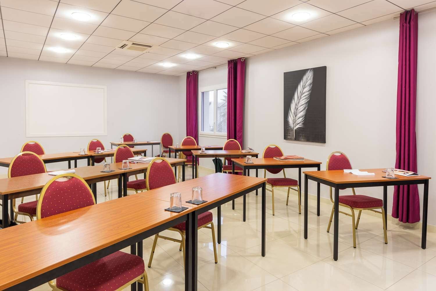 A conference room with multiple tables and chairs, a whiteboard, and a window with curtains.