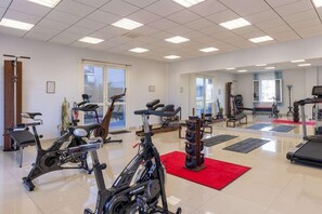 A spacious gym with various exercise equipment, including treadmills, stationary bikes, and weight machines. - Best Western Hotel & SPA Pau Lescar Aeroport (Lescar)