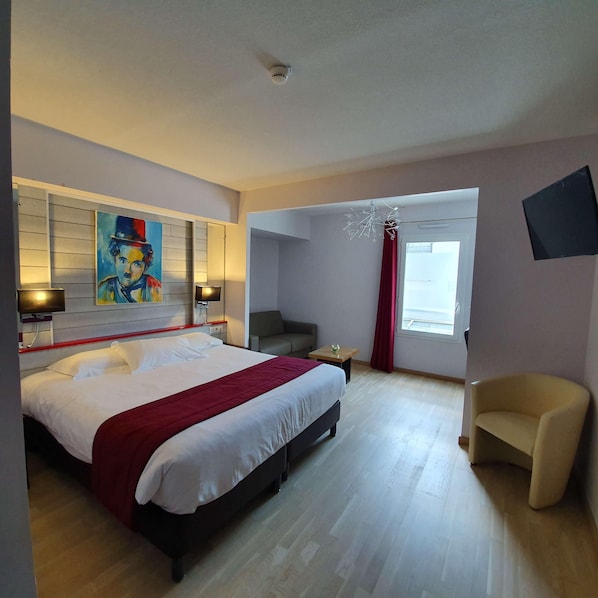A hotel room with a large bed, a desk, a chair, a painting on the wall, and a window with curtains. - Best Western Hotel & SPA Pau Lescar Aeroport (Lescar)