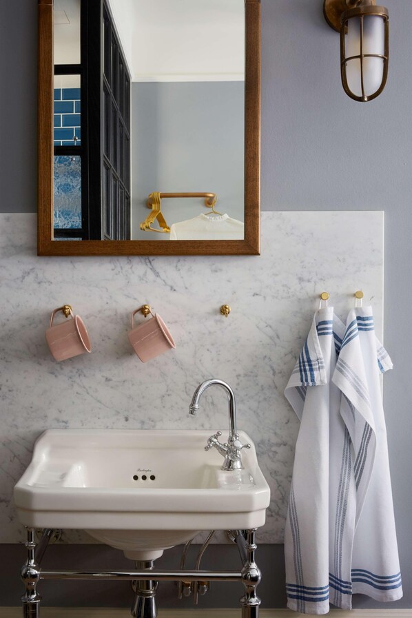 A bathroom with a white sink, a mirror, and towels.