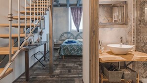 A bedroom with a bed, a wooden staircase, a bathroom with a large sink, and a window with curtains. - Trieste Art Loft (Trieste)
