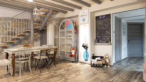 A dining area with a wooden table and chairs, a staircase, a fire extinguisher, and a chalkboard with writing. - Trieste Art Loft (Trieste)