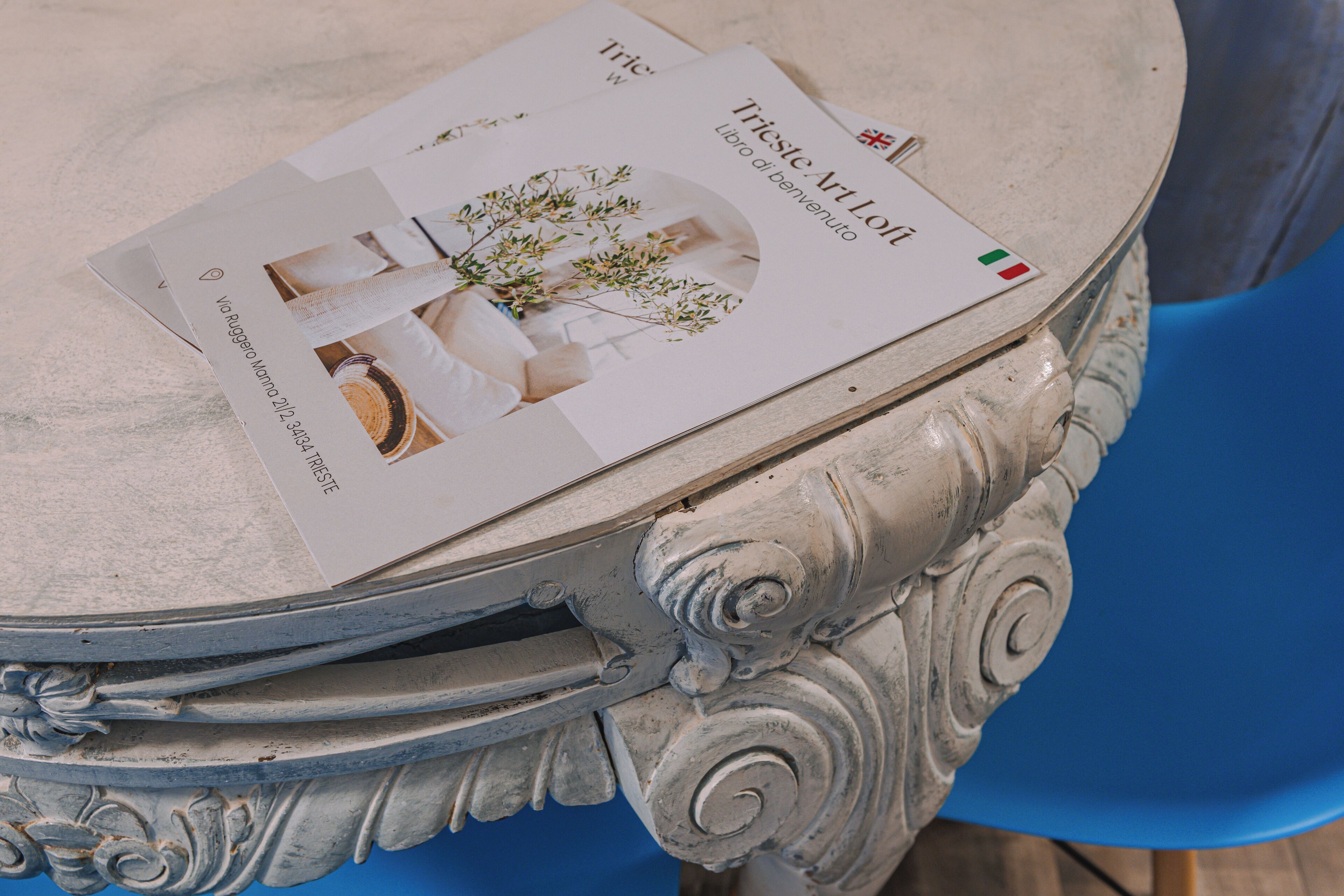 A brochure titled "Triste Art" on a table with ornate carvings.