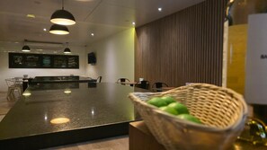 A modern interior with a long counter, pendant lighting, and a menu board.