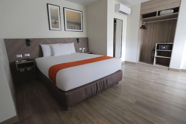 A modern hotel room with a large bed, a wardrobe, and a small desk. - Casa Andina Standard Trujillo Plaza (Trujillo)