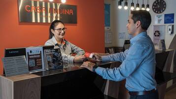 A reception desk with a sign reading 'CASA ANDINA STANDARD' and Lenovo promotional materials.